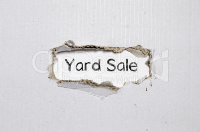 The word yard sale appearing behind torn paper.