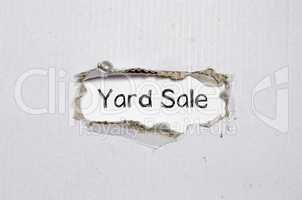 The word yard sale appearing behind torn paper.