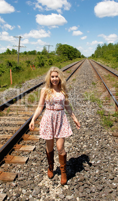 Young woman walking on railroad track's.