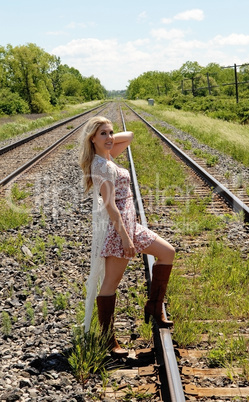 Young woman standing on railroad track's.