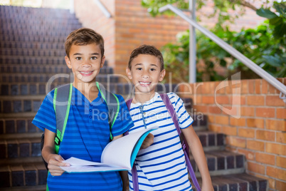 School kids holding a book on staircase