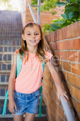 Smiling schoolgirl standing on staircase