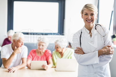 Nurse with arms crossed in front of seniors