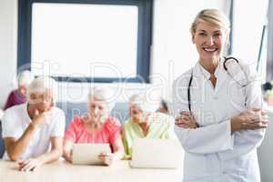 Nurse with arms crossed in front of seniors