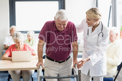 Nurse helping senior with walking aid