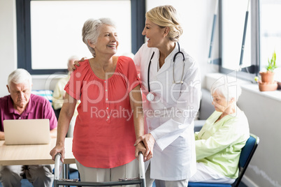 Nurse helping senior with walking aid