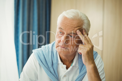 Sad senior man touching his head