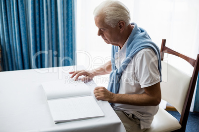 Senior man using braille to read