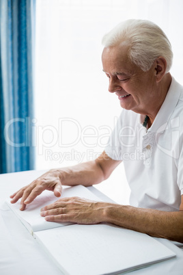 Senior man using braille to read