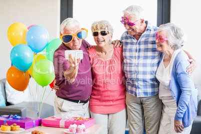 Seniors taking a selfie with funny glasses