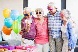 Seniors taking a selfie with funny glasses