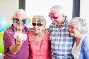 Seniors taking a selfie with funny glasses