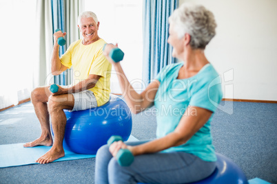 Seniors using exercise ball and weights