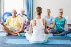Instructor performing yoga with seniors