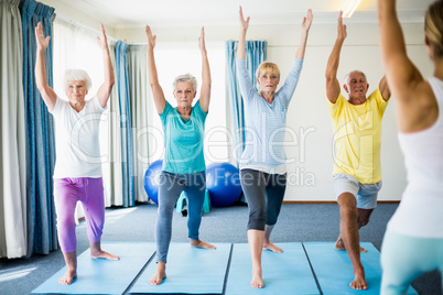 Instructor performing yoga with seniors