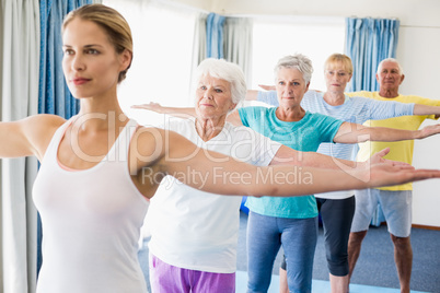 Instructor performing yoga with seniors