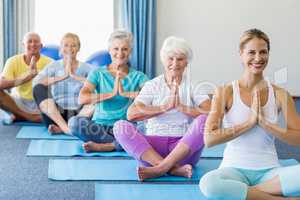 Instructor performing yoga with seniors