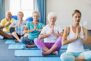 Instructor performing yoga with seniors