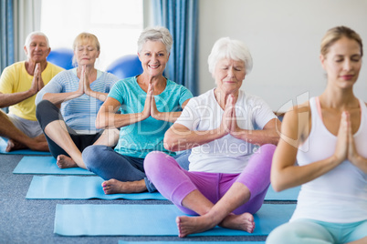 Instructor performing yoga with seniors Instructor performing yoga with seniors