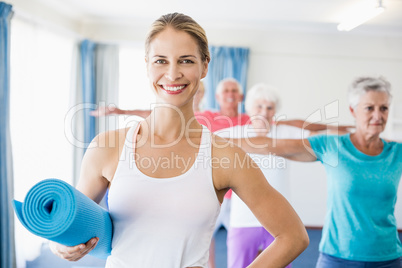 Instructor holding yoga mat