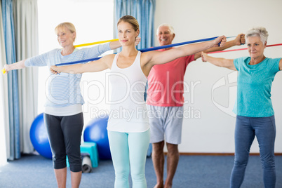 Instructor and seniors exercising with stretching bands