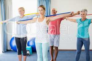 Instructor and seniors exercising with stretching bands