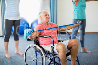 Senior in wheelchair exercising with exercising band