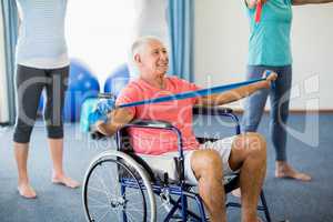Senior in wheelchair exercising with exercising band