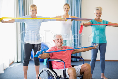 Instructor and seniors exercising with stretching bands