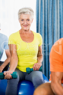 Seniors using exercise ball and weights