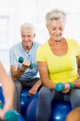 Seniors using exercise ball and weights