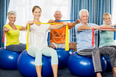 Seniors using exercise ball and stretching bands