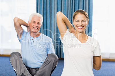 Instructor helping senior man with sport exercises