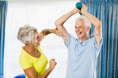Senior woman feeling muscles of man