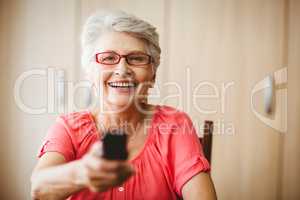 Senior woman holding a remote control