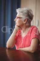 Thoughtful senior woman sitting at a table