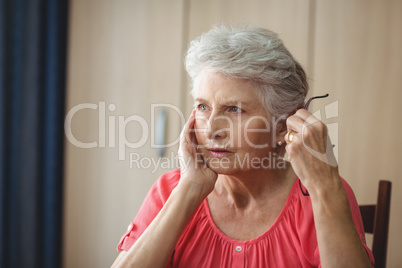 Thoughtful senior woman sitting at a table