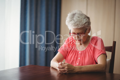 Thoughtful senior woman sitting at a table