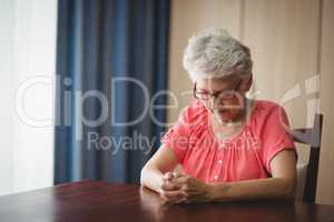 Thoughtful senior woman sitting at a table