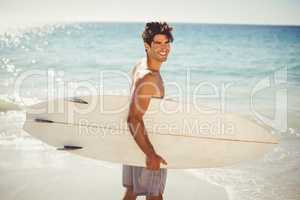 Man holding surfboard on beach