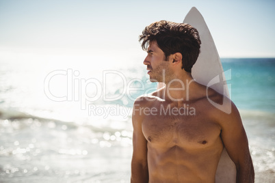 Man holding surfboard on beach