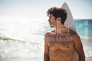 Man holding surfboard on beach