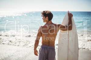 Man holding surfboard on beach