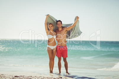 Couple holding towel on beach
