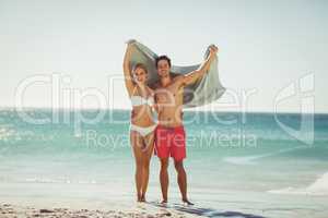 Couple holding towel on beach