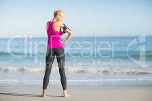 Sportswoman using mobile phone on beach