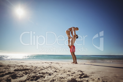 Man lifting woman at beach