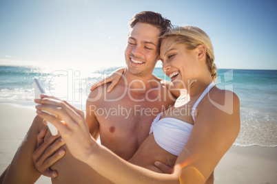 Young couple taking selfie on beach