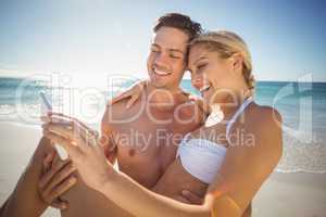 Young couple taking selfie on beach