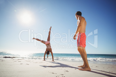 Woman performing somersault on beach